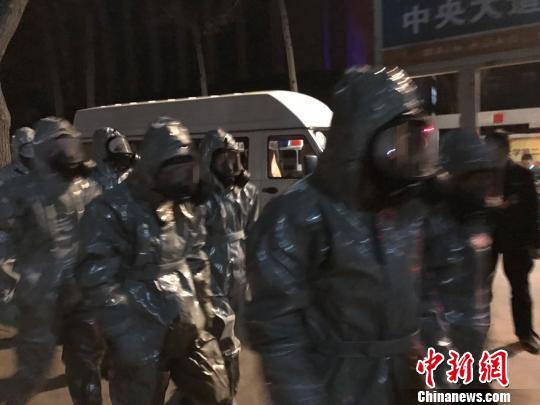 十几名身着防护服的人员头戴面具进入事发地。　胡健 摄